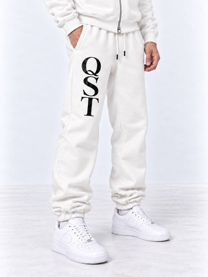 Black cuffed joggers with stacked white QST serif monogram on the thigh