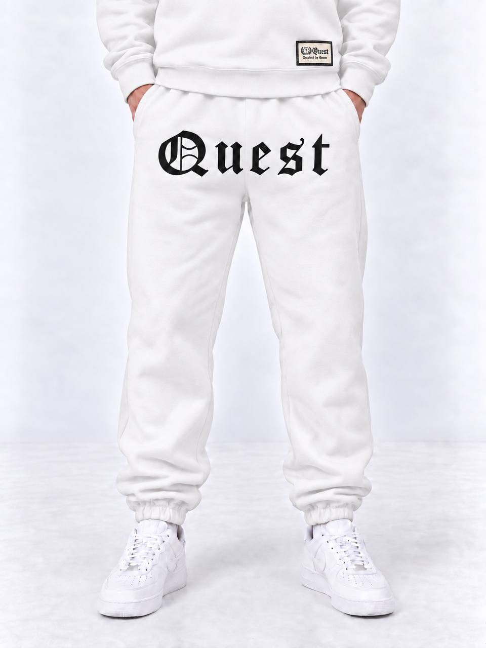 Black cuffed joggers with white blackletter Quest thigh print